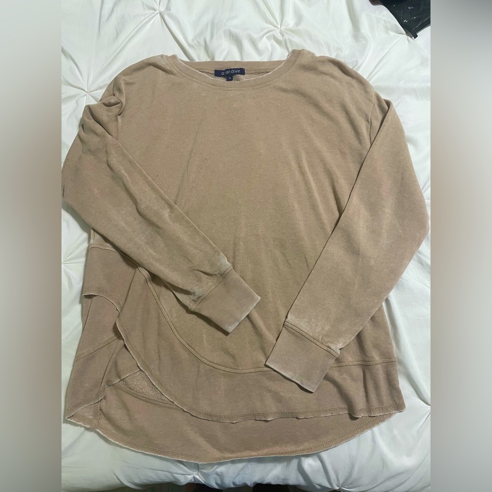 Never worn tan colored sweater, cross on the bottom, Very soft inside and out.